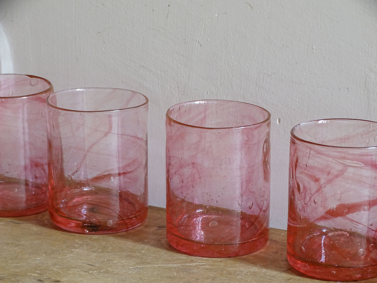 Vintage handmade pink glass tumblers with swirling colour and trapped bubbles