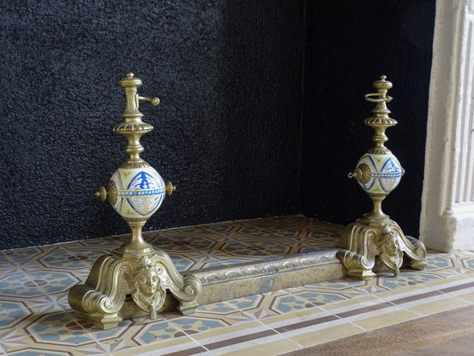Pair of French antique brass andirons with fender and painted ceramic globes