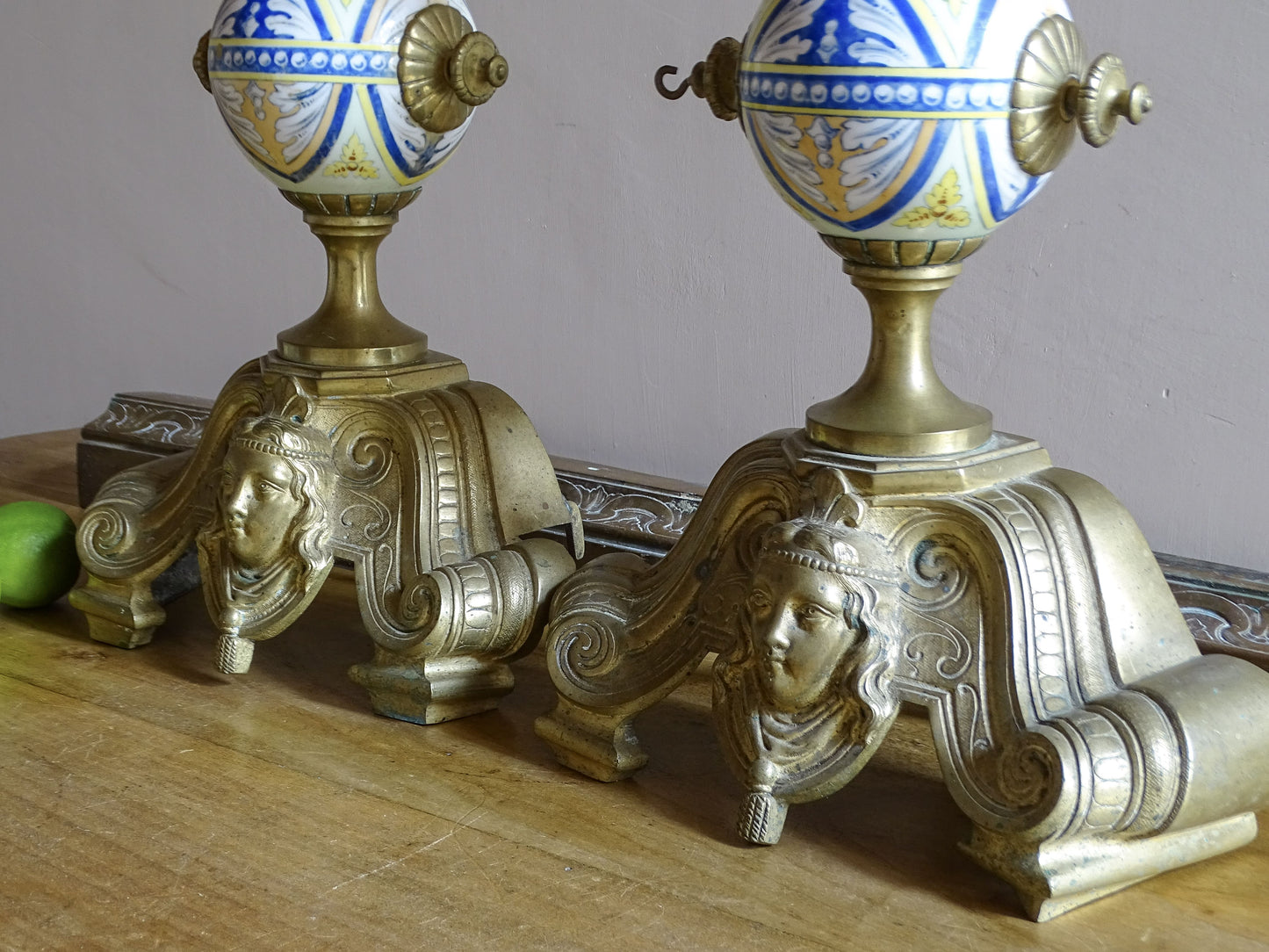 Neo-Renaissance detail on antique French brass chenet with female mascaron and architectural scrollwork