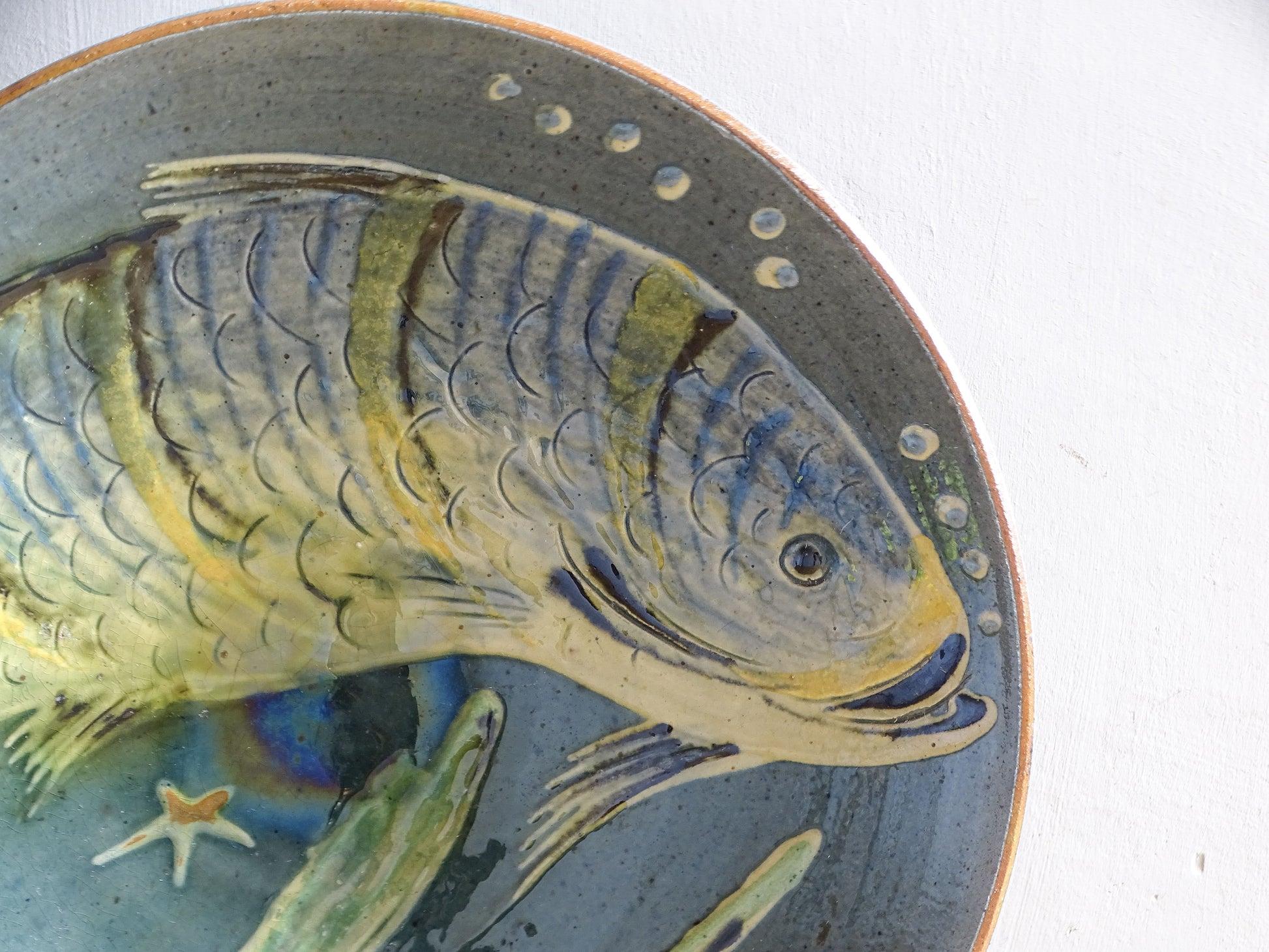 Vintage Spanish pottery fish plate with blue-grey glaze and incised decoration