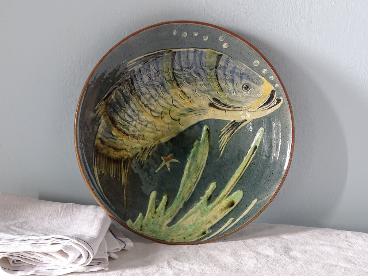 Spanish vintage ceramic plate with fish design, pictured with antique linen