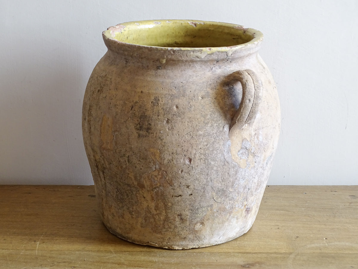 Large antique French confit pot with yellow glazed interior and aged terracotta finish