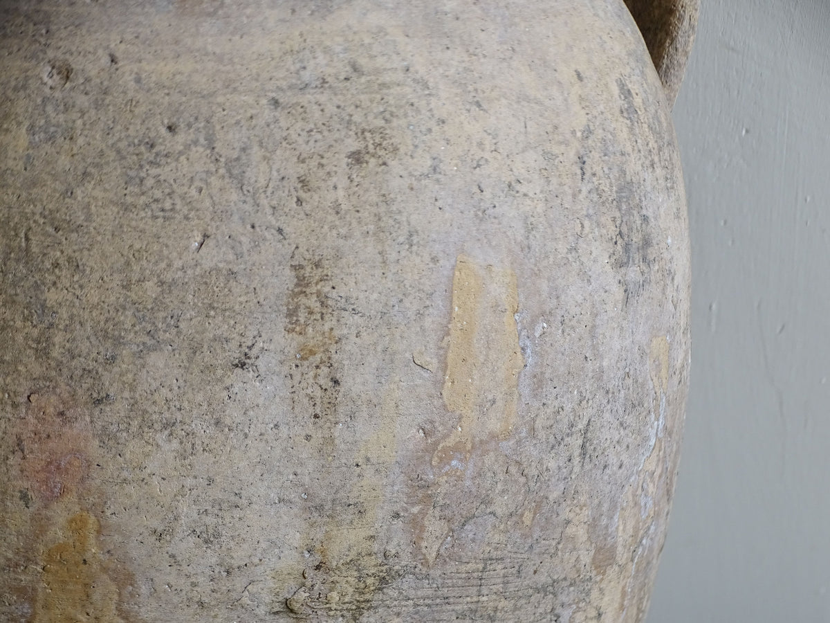 Close-up of yellow glazed rim and weathered earthenware surface on antique French pot
