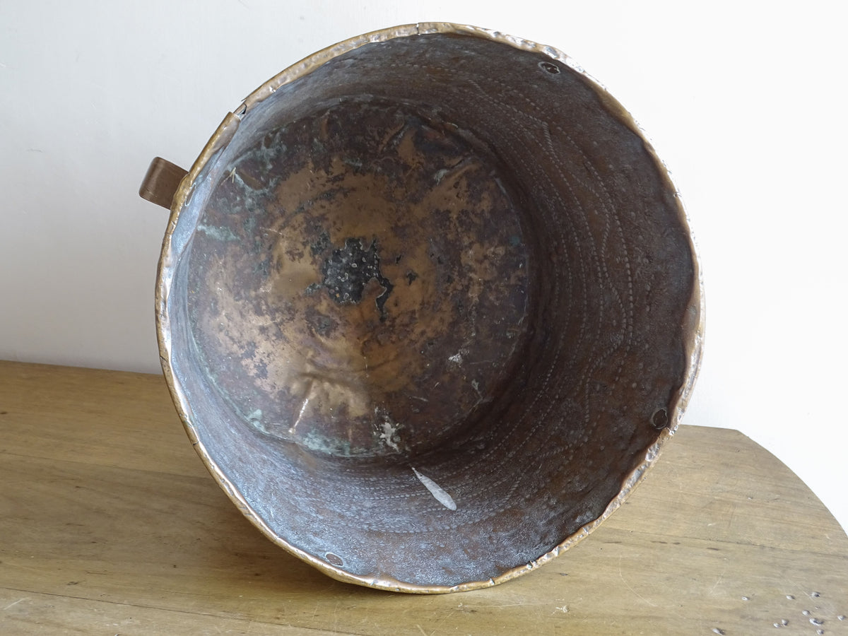 Hammered interior of an 18th century French copper vessel with dark aged patina and old repairs