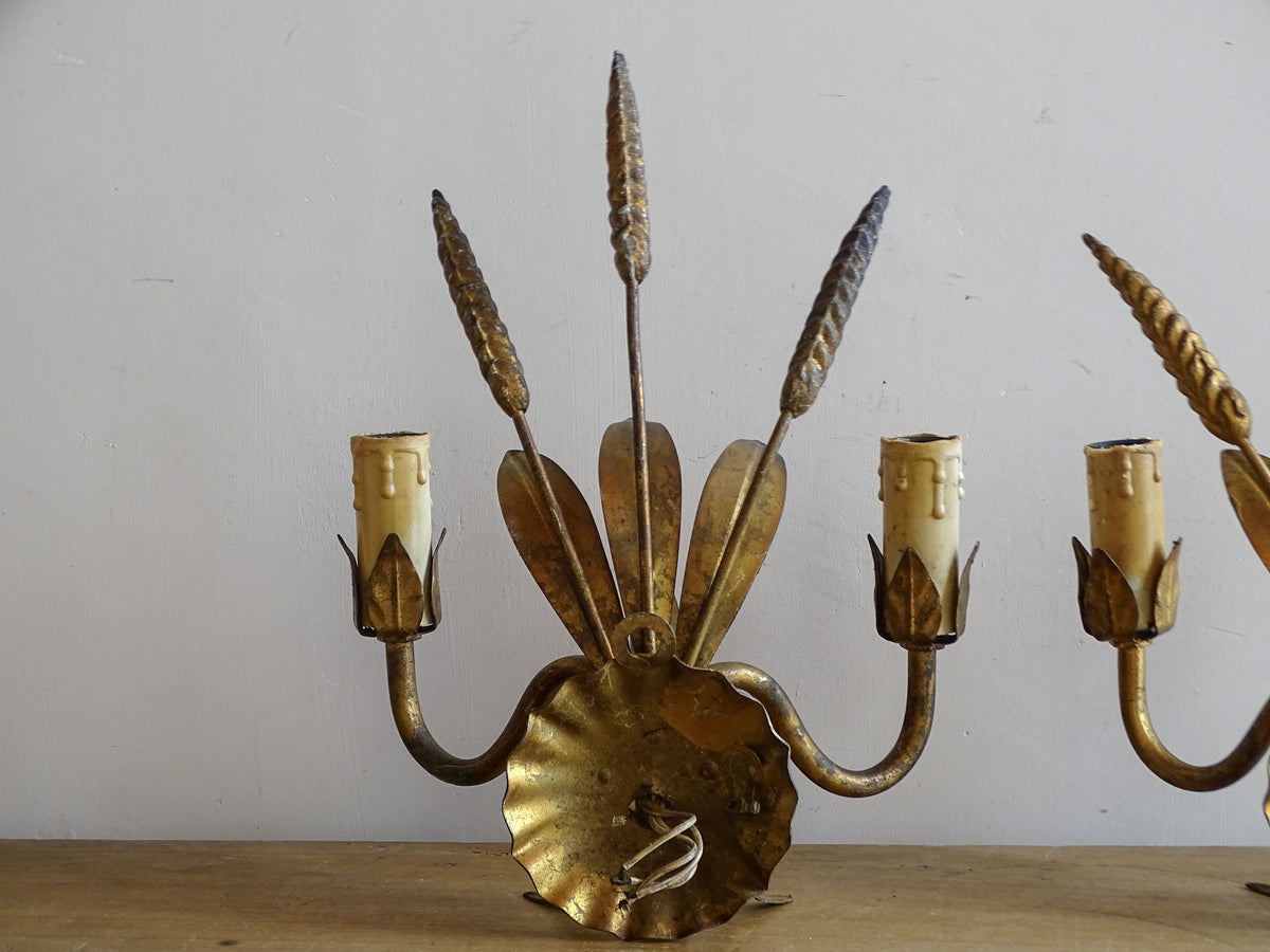Close-up of scalloped backplate and layered gilt metal leaves on French wall light