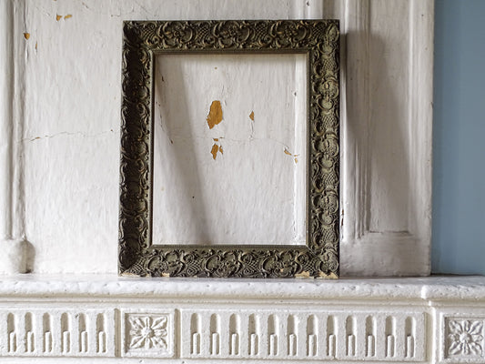 Full view of French 19th-century ornate Louis XV style frame with aged green-grey and gilt finish displayed on a country fireplace