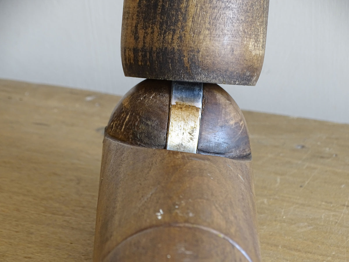 Detail of the metal articulation mechanism within a vintage wooden mannequin elbow joint