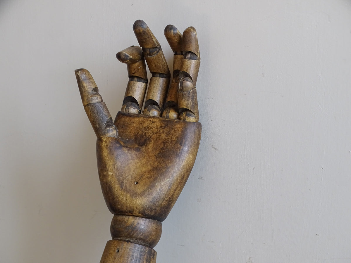 Mid-century wooden mannequin arm with articulated hand and naturally worn surface