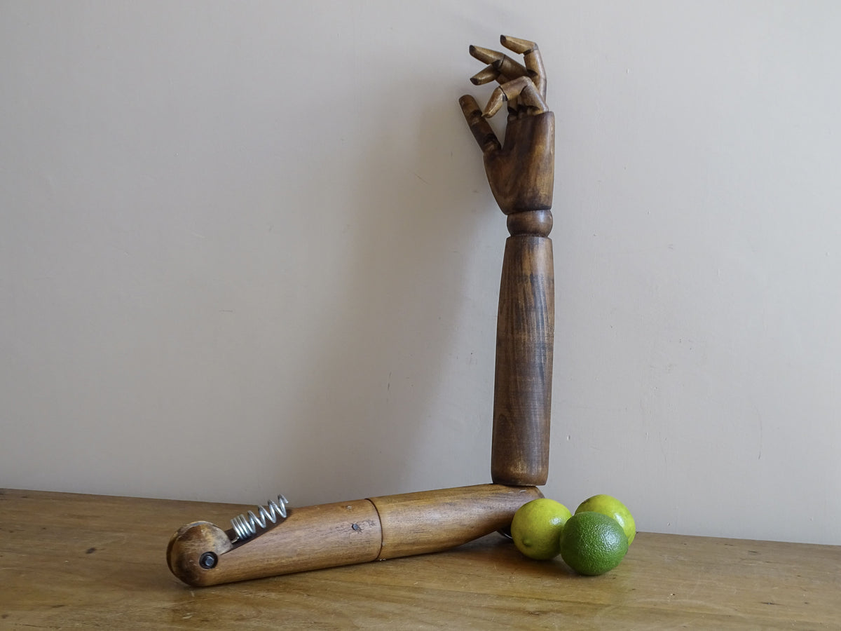 Articulated wooden mannequin hand posed with bent fingers showing the movable joints