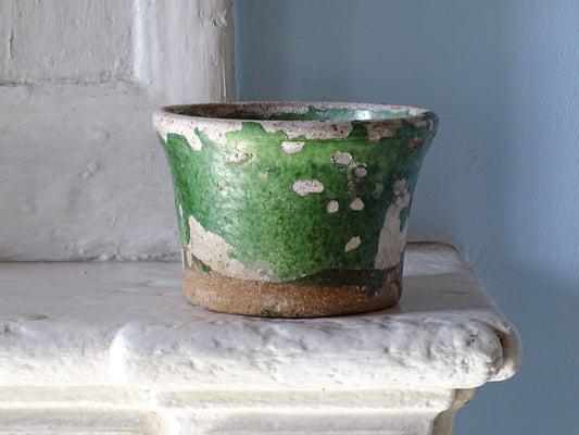 Antique French 19th-century green glazed earthenware pot pictured on a country house fireplace with pale blue wall