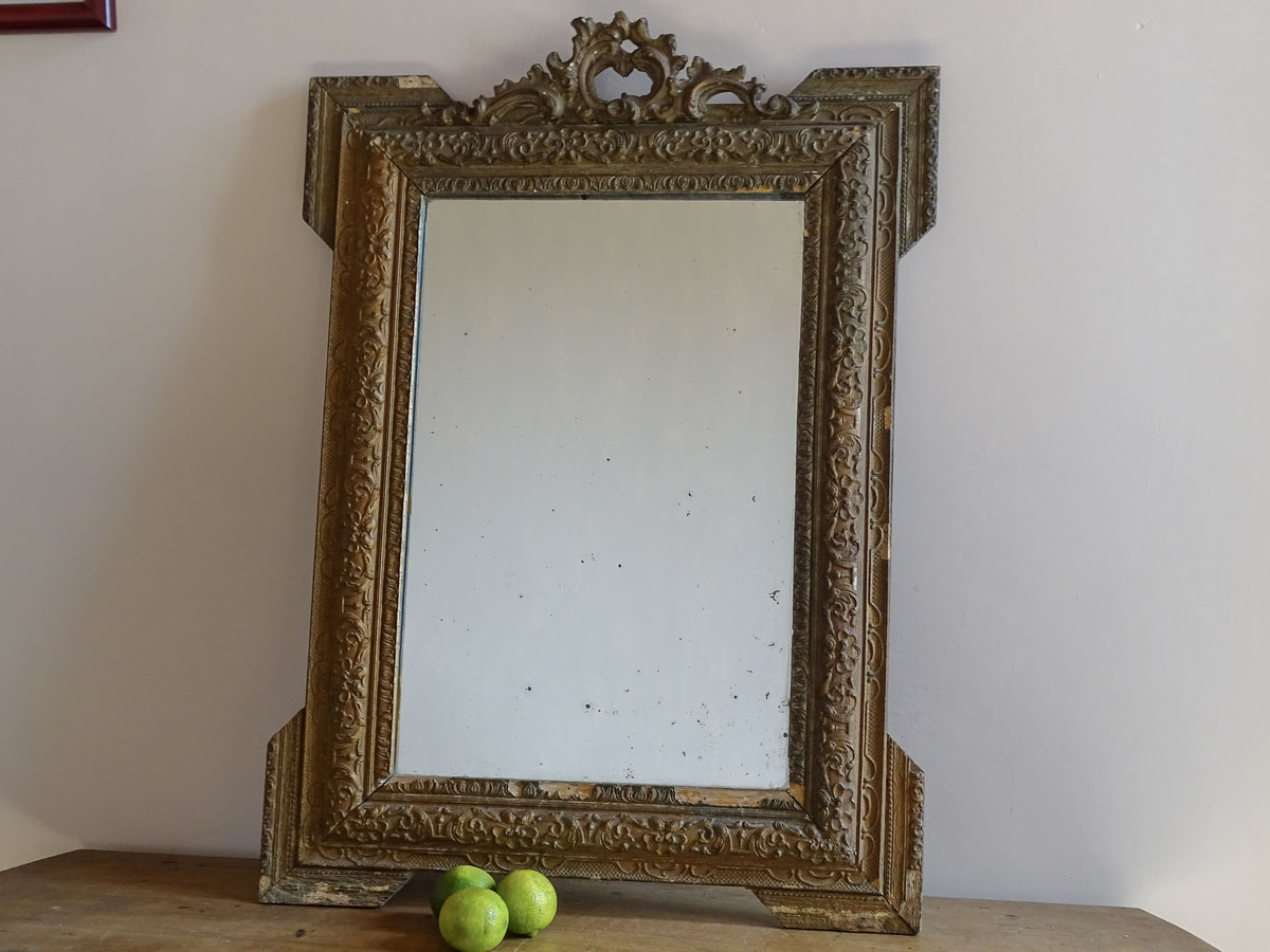 19th-century French giltwood mirror with decorative stucco frame and pierced crest