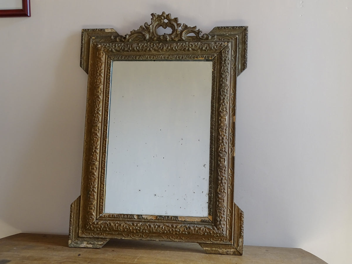 Pierced rocaille-style crest on an antique French giltwood and stucco mirror