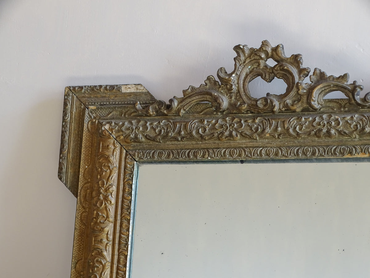 Upper corner detail of antique French gilt mirror with moulded floral and scroll decoration