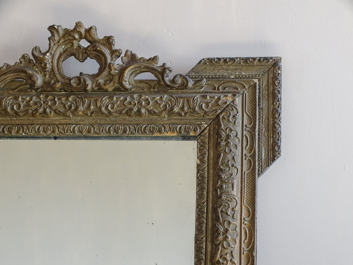 : 19th-century French giltwood mirror with decorative stucco frame and pierced crest