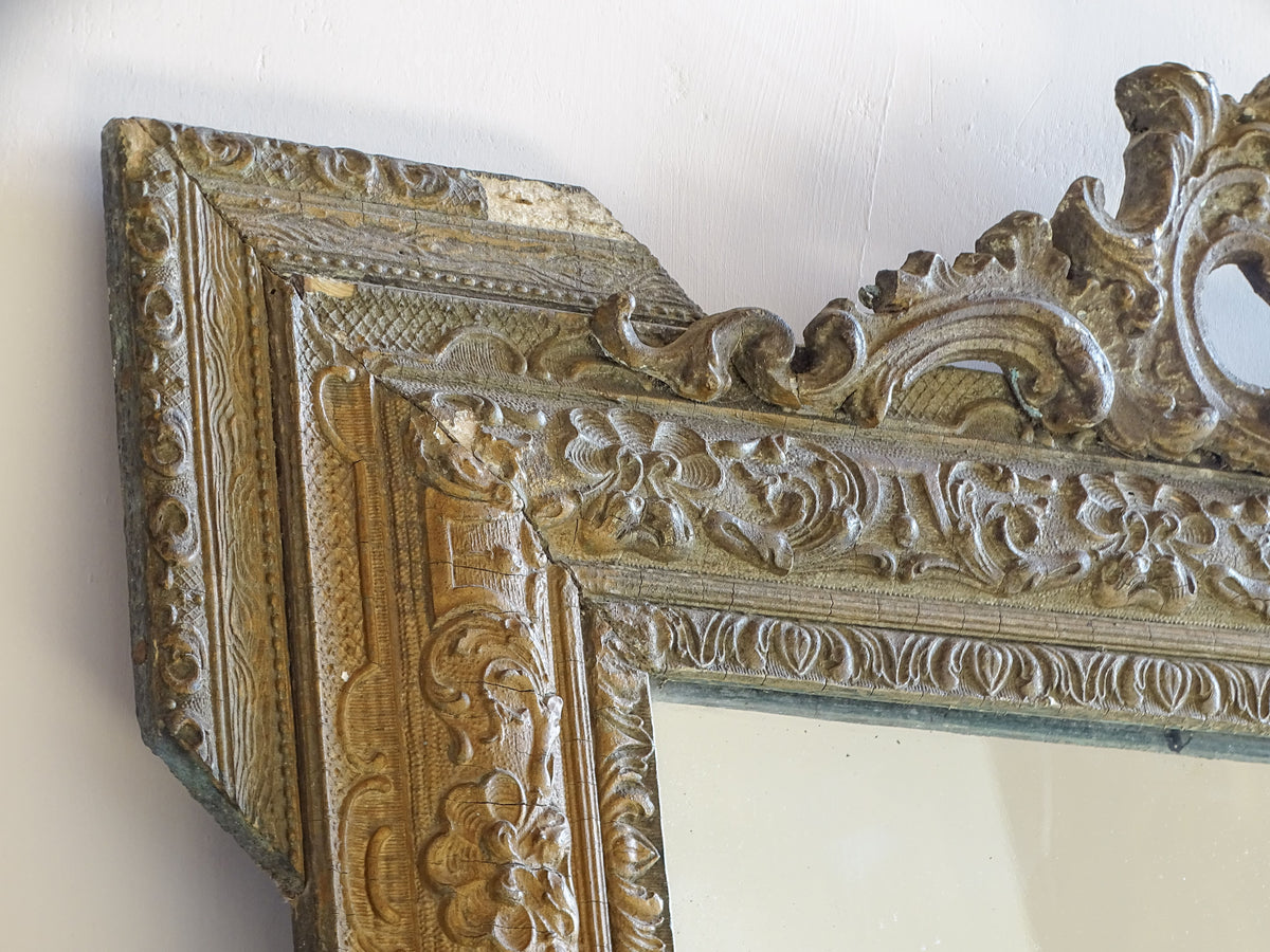 854h: Close-up of aged gold finish and moulded stucco decoration on a French antique mirror