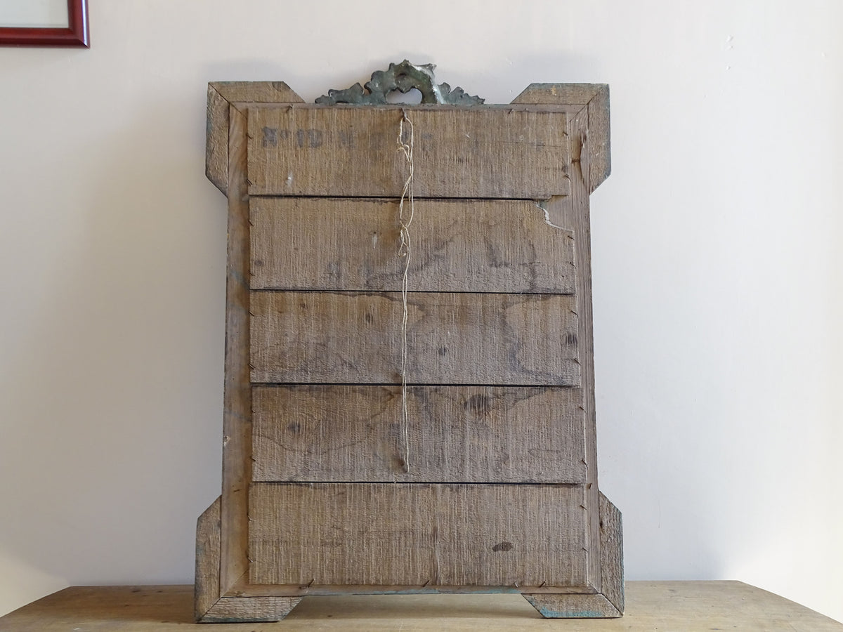 Back detail of wood and stucco antique mirror
