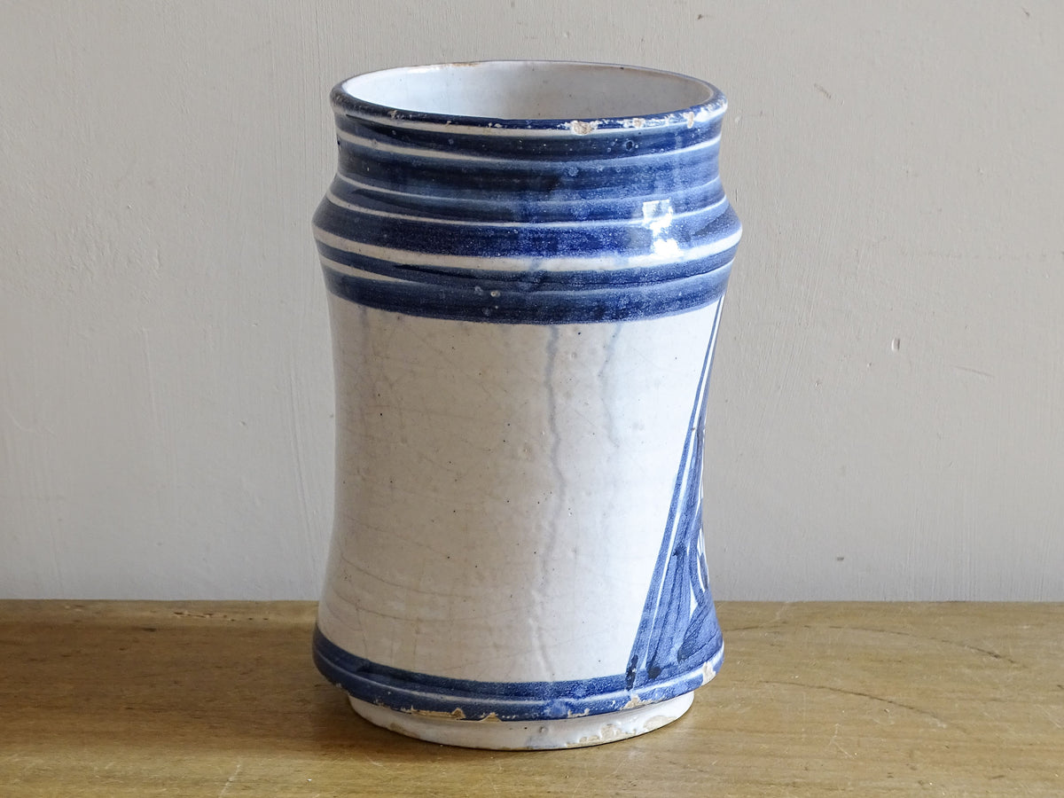 Side view of antique Spanish blue and white albarello showing aged glaze