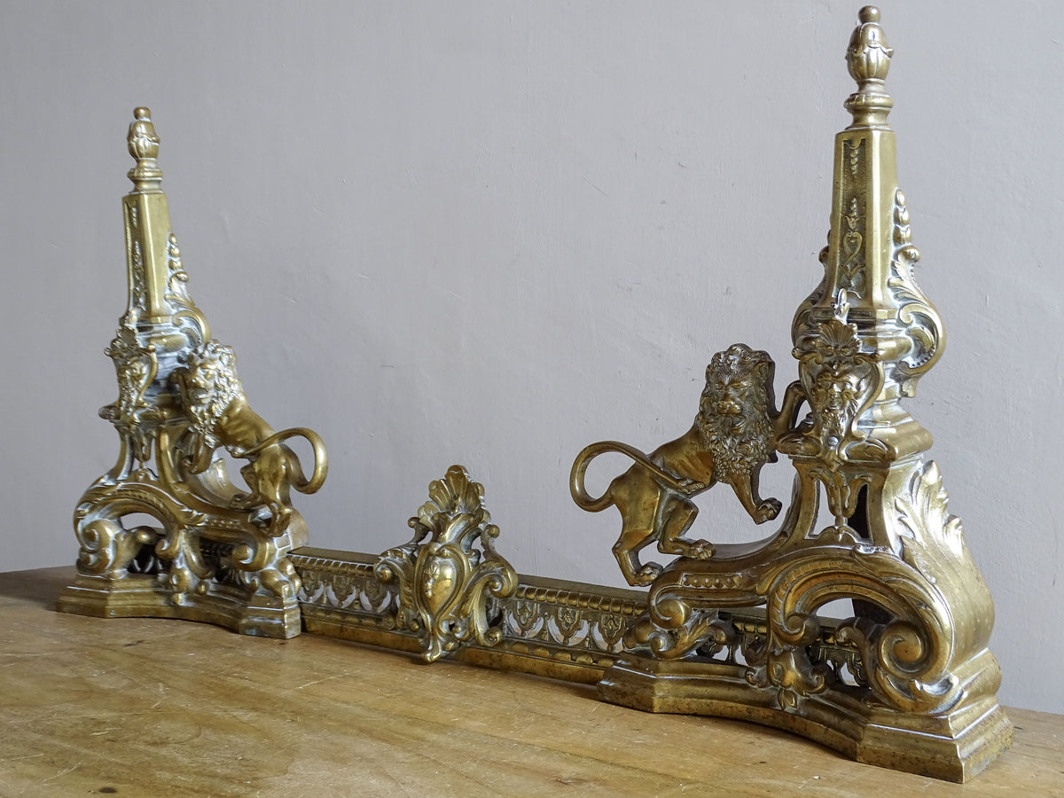 Angled view of a 19th century French brass fireplace fender with lions
