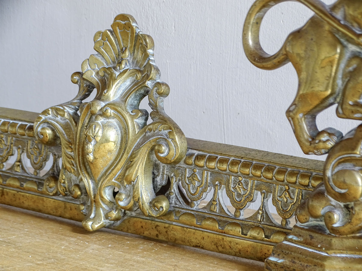 Rocaille cartouche and pierced brass rail on a French antique fireplace fender