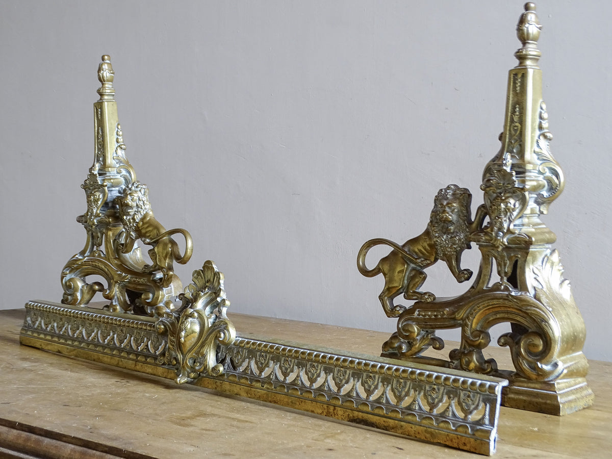 Angled view of an ornate French Napoleon III brass fireplace fender