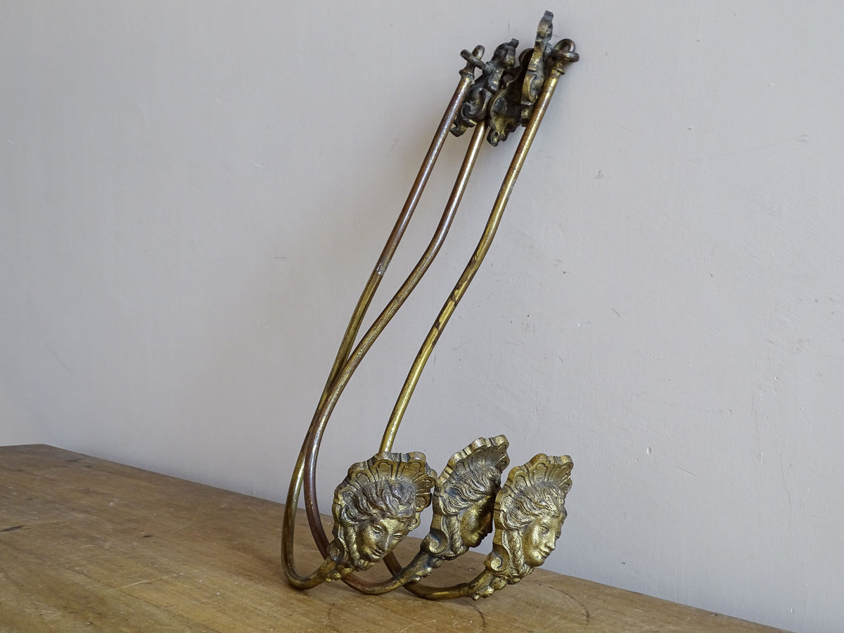  Three French antique gilt metal curtain holdbacks with classical female mask decoration