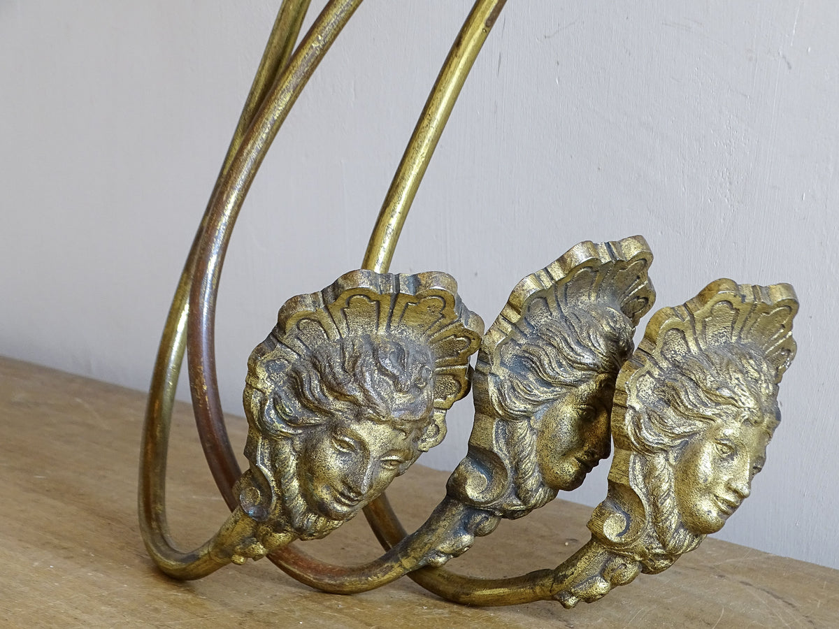 Set of three antique French gilt curtain holdbacks with long curved arms and female masks