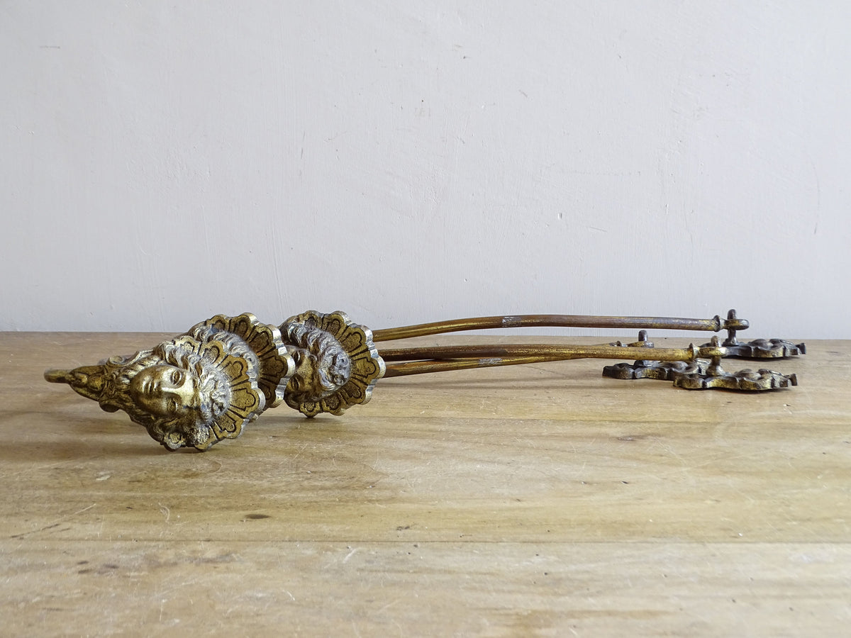 Classical female mask terminals on a set of French antique gilt curtain holdbacks