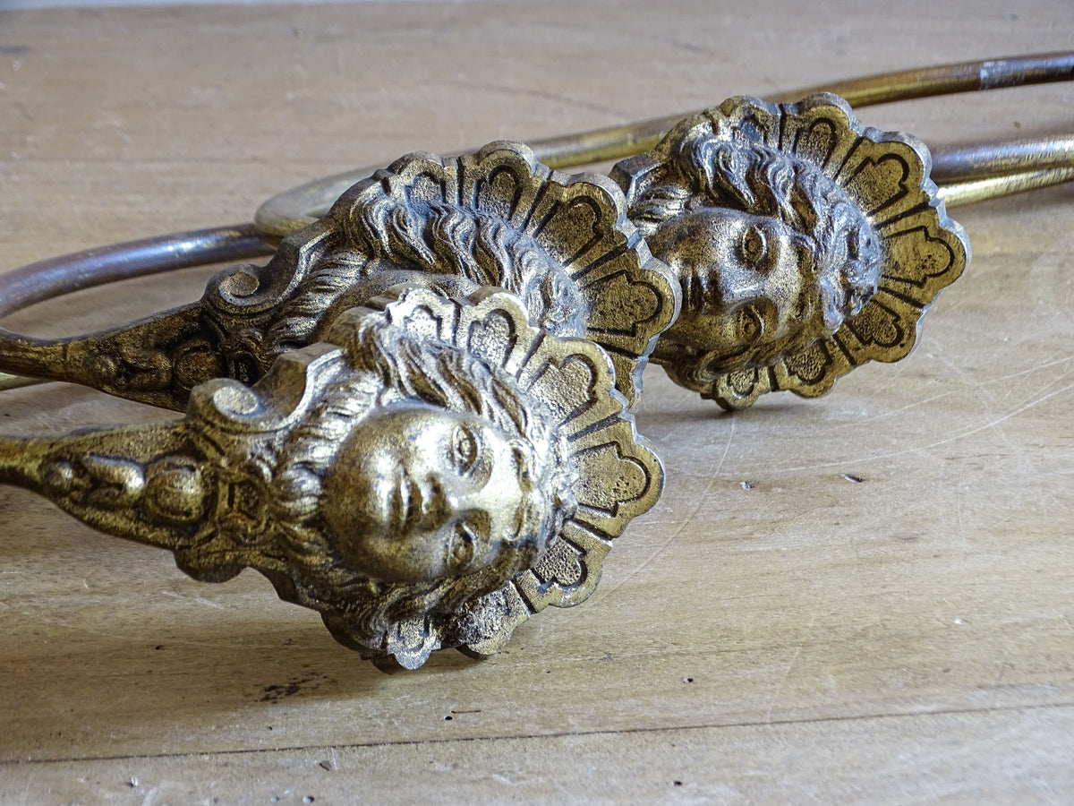  Detail of classical female faces on French antique gilt metal curtain holdbacks