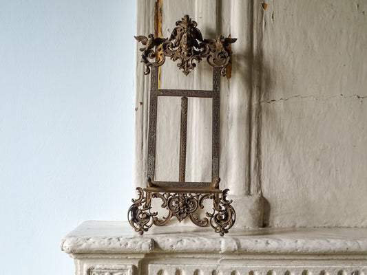 German antique cast iron tabletop easel by E.G. Zimmermann, 19th century, displayed on an aged stone mantelpiece