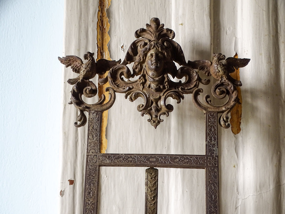 Decorative crest of an antique E.G. Zimmermann cast iron easel featuring a female portrait, winged birds and scrolling foliage