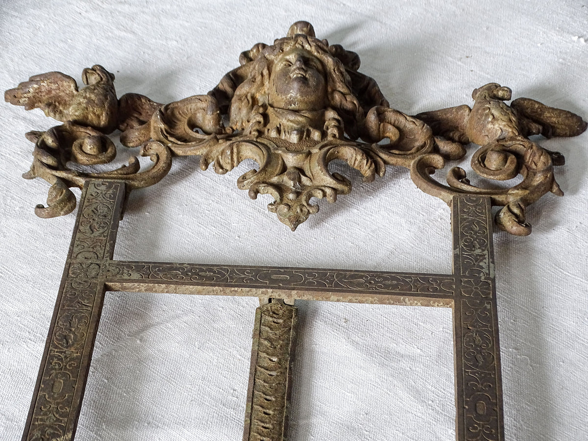Close-up of the ornate upper section of a 19th-century German easel with sculpted female bust and two winged birds