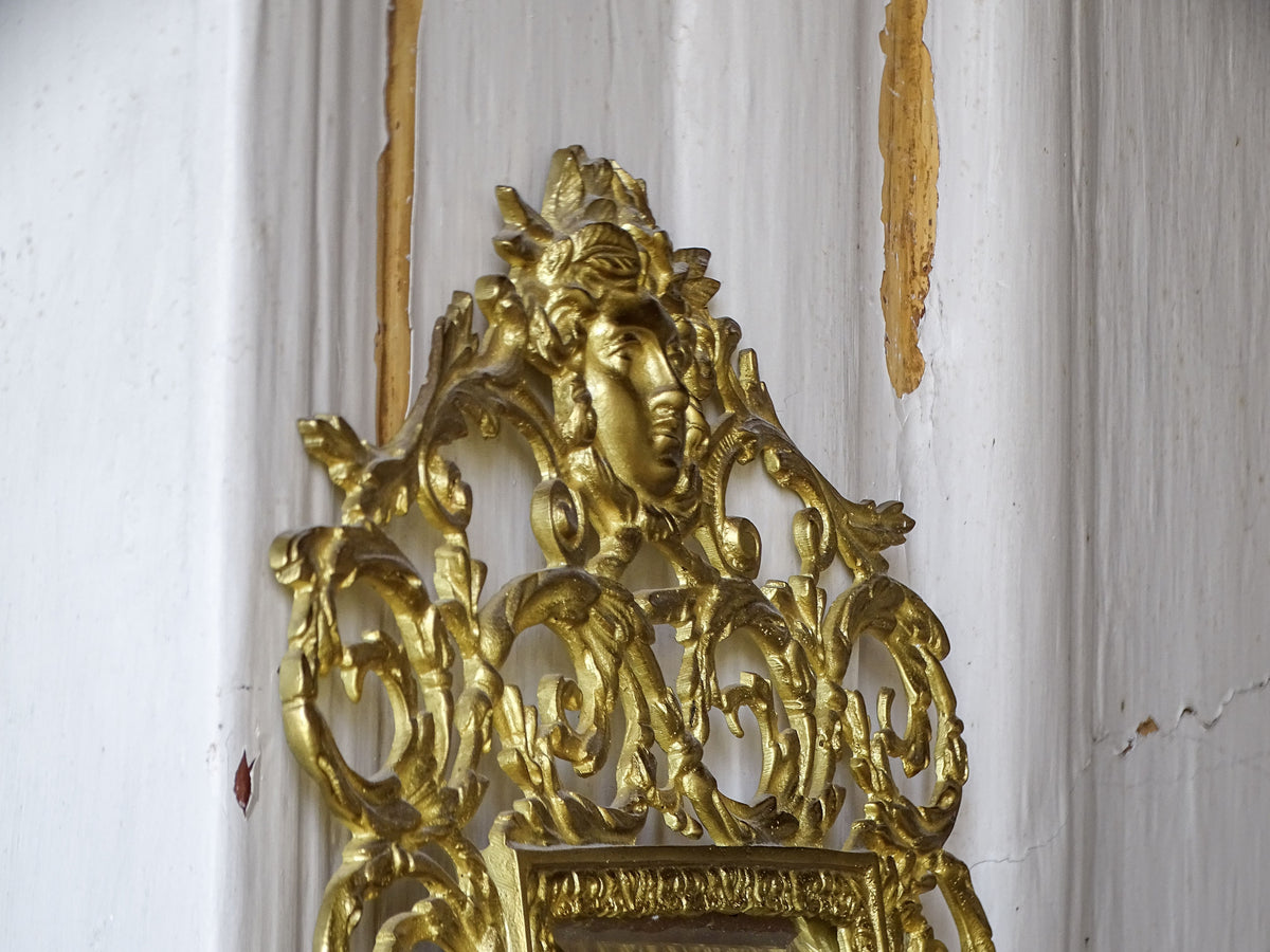 Side view of the sculpted classical female face crowning the ornate Napoleon III mirror frame