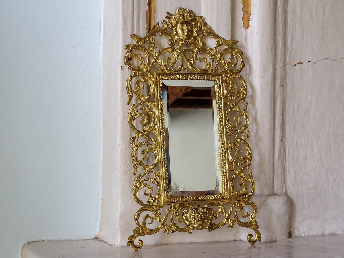 French Napoleon III gilt metal wall mirror with ornate openwork frame, classical masks and rectangular bevelled glass