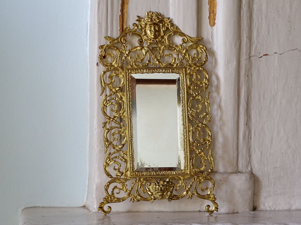French Napoleon III gilt metal wall mirror with ornate openwork frame, classical masks and rectangular bevelled glass