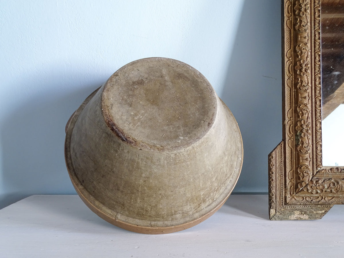 Underside of a large French stoneware mixing bowl showing its unglazed base and natural grey-beige exterior.