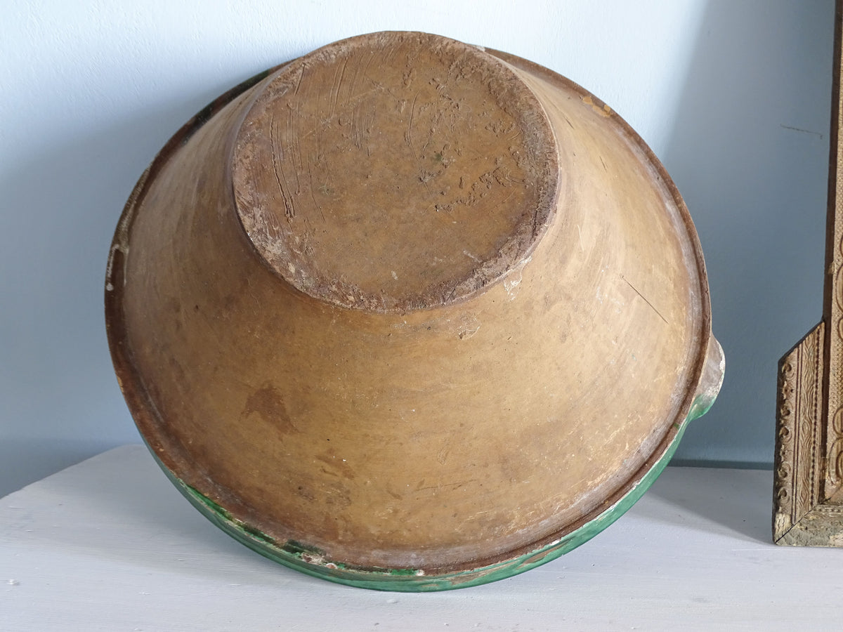 Base of a 19th-century French terracotta tian bowl showing its circular foot and naturally aged earthenware surface.