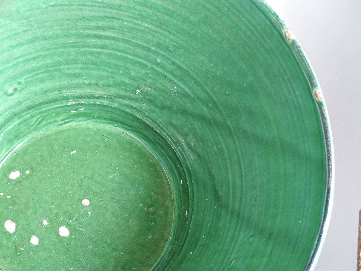 Detail of the green glaze and concentric throwing marks inside a large antique French pottery tian bowl.