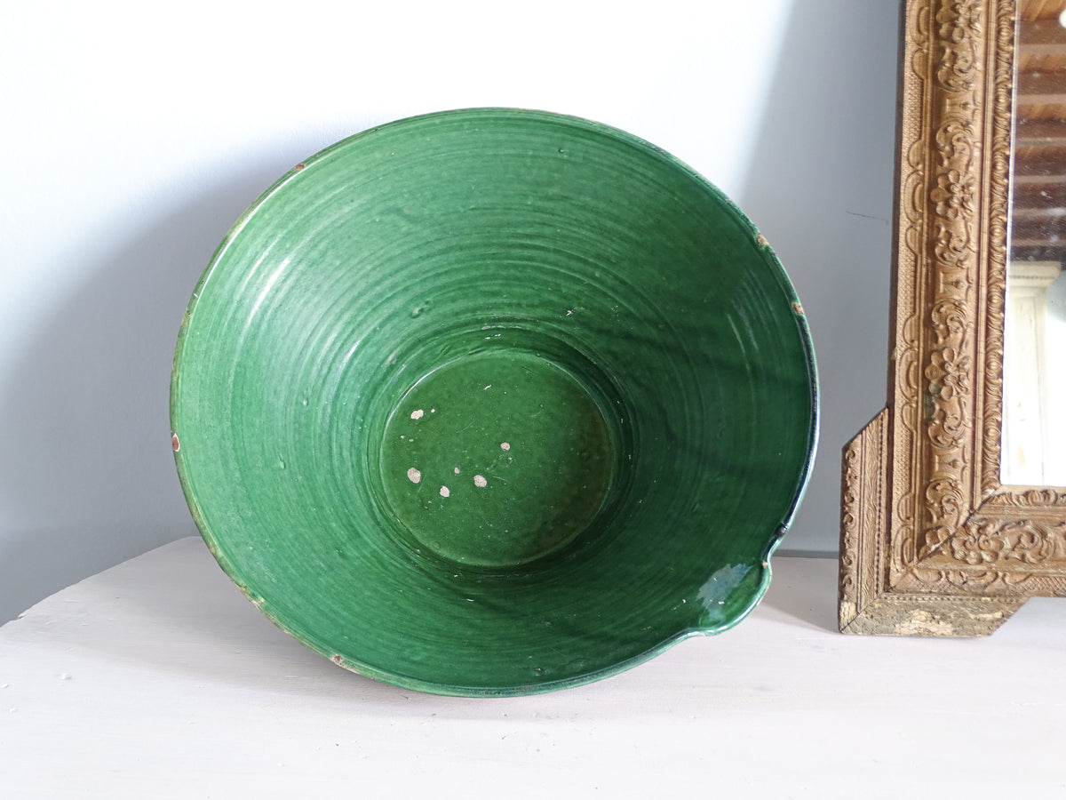 Large antique French green glazed tian bowl viewed from above, showing its traditional shape and pouring lip.