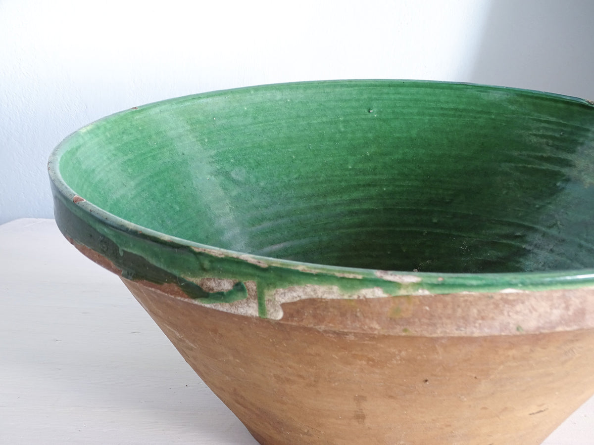 Close-up of the worn green glazed rim and unglazed terracotta exterior of a 19th-century French tian bowl.