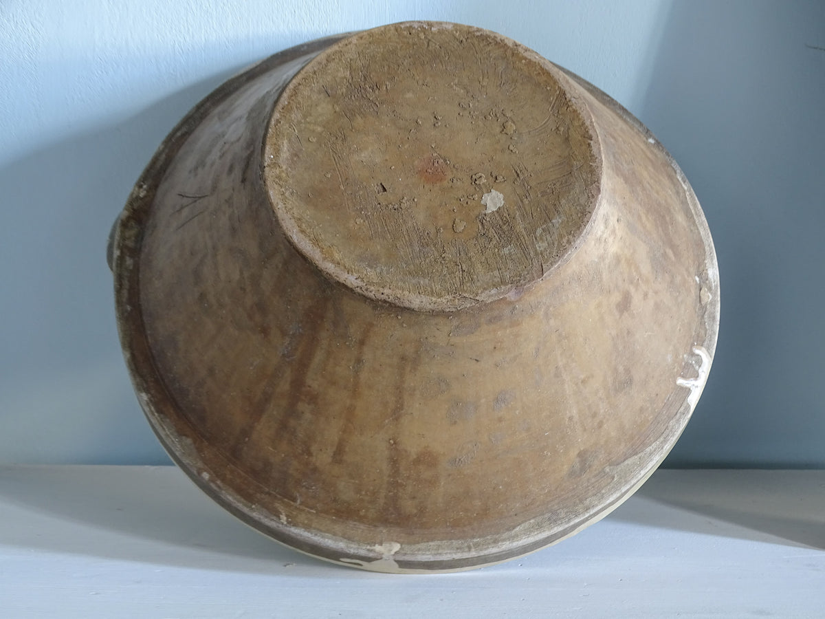 Base of a French antique terracotta tian bowl showing traditional pottery construction, natural clay colouring and an unglazed circular foot.