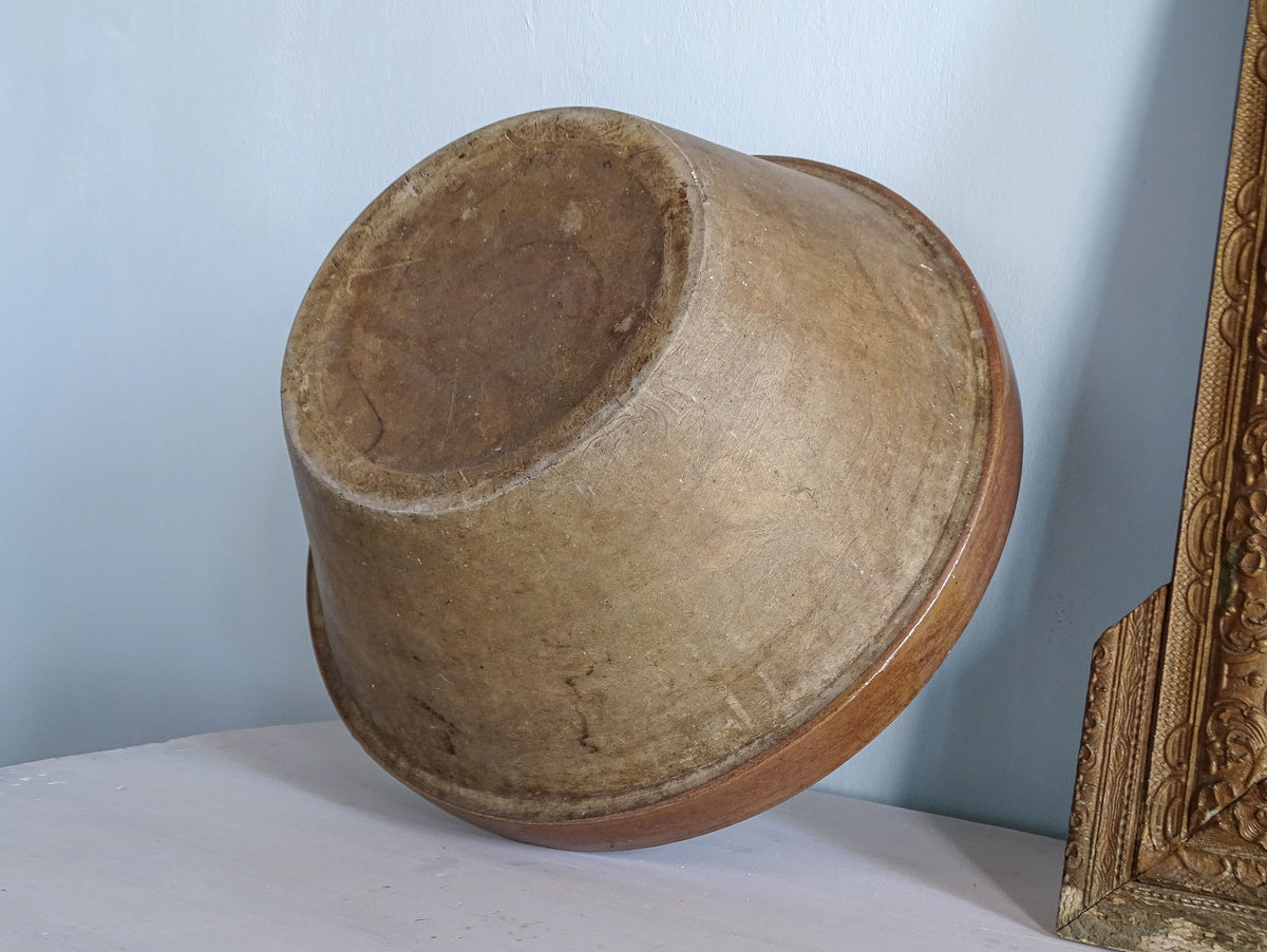 Underside of a large French antique pottery mixing bowl showing its naturally aged exterior and circular base.