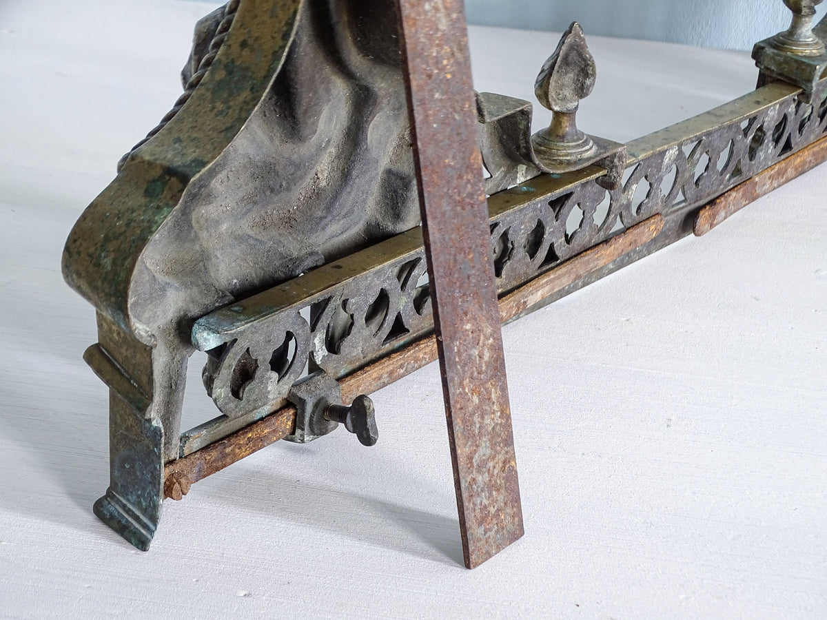 Close-up of adjustable iron mechanism and screw fixing on antique French brass fireplace fender