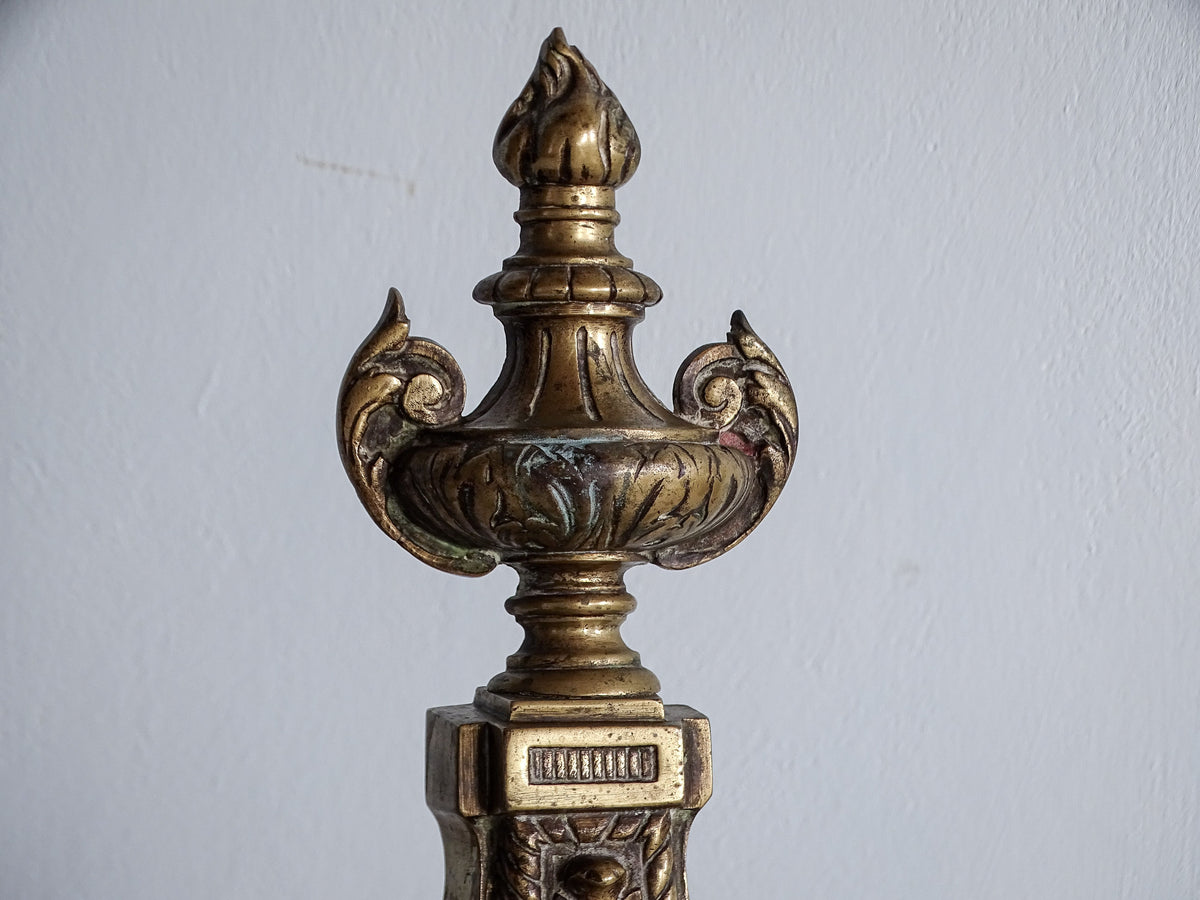 Decorative brass urn-shaped finial with flame top on an antique Napoleon III fireplace chenet