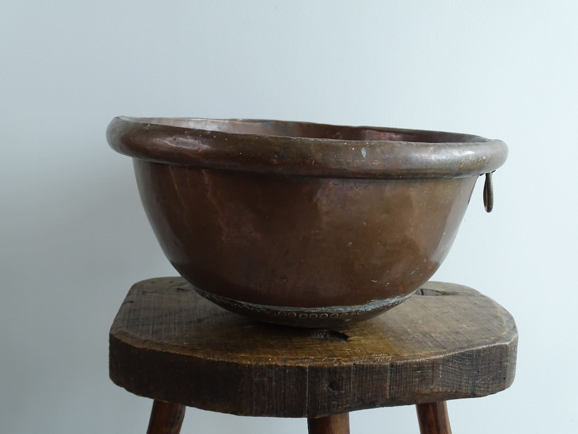 Antique French Copper Confectioner's or Mixing Bowl from the 18th Century. This timeworn copper bowl has a rolled top and copper rivets to the curved base. 