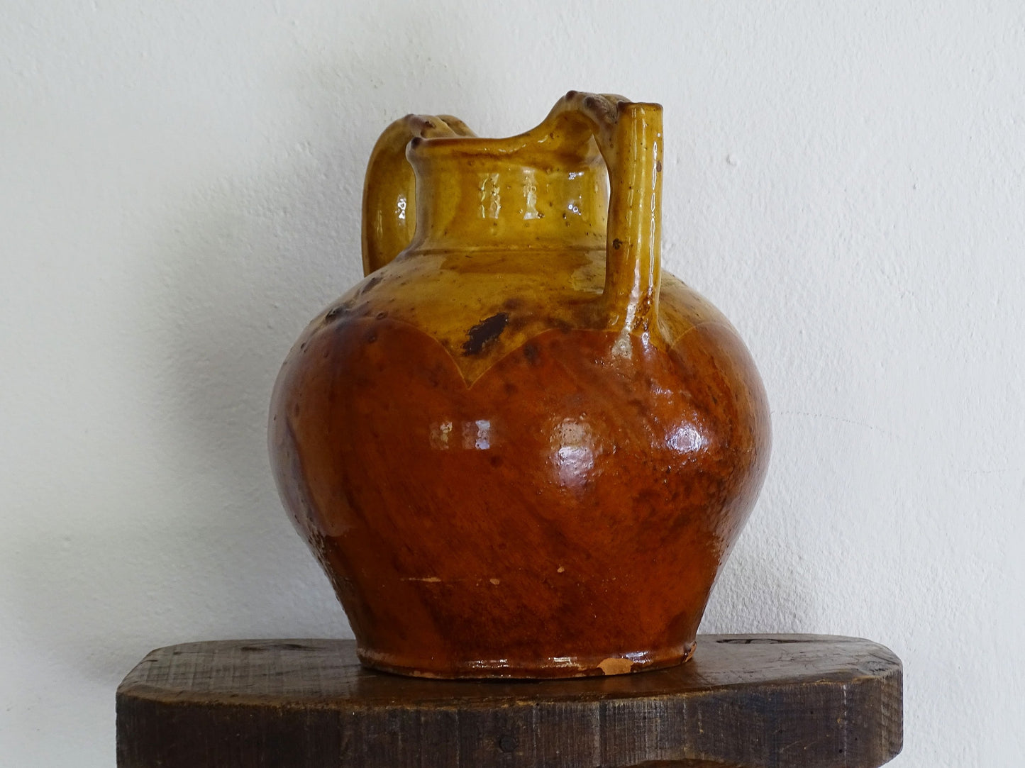 antique French orjol or pitcher in golden caramel yellow glaze, pottery cruche or jug with two handles and spout from Languedoc in South of France.