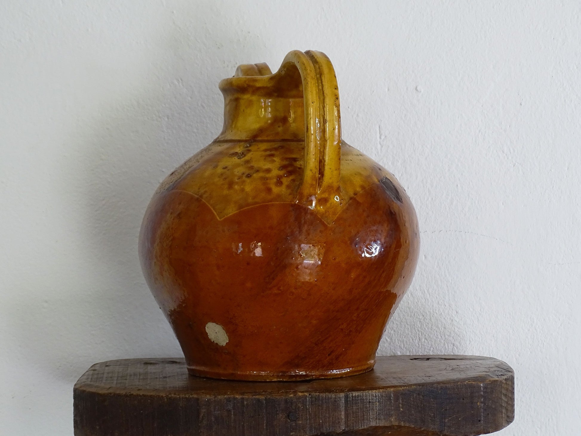 An antique French orjol or pitcher in golden caramel yellow glaze, pottery cruche or jug with two handles and spout from Languedoc in South of France.