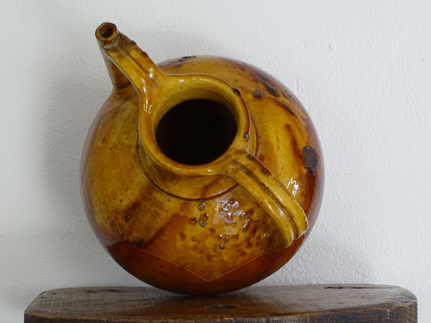 antique French orjol or pitcher in golden caramel yellow glaze, pottery cruche or jug with two handles and spout from Languedoc in South of France.