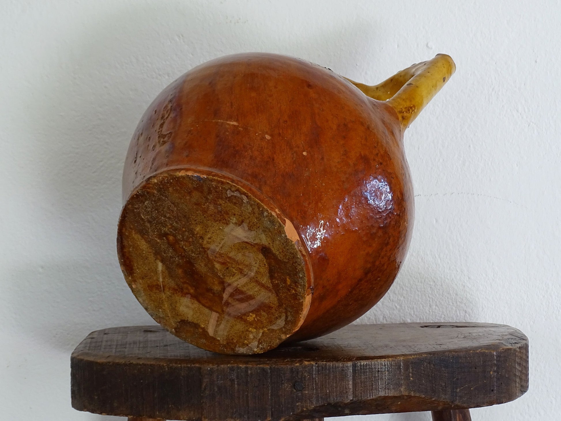 antique French orjol or pitcher in golden caramel yellow glaze, pottery cruche or jug with two handles and spout from Languedoc in South of France.