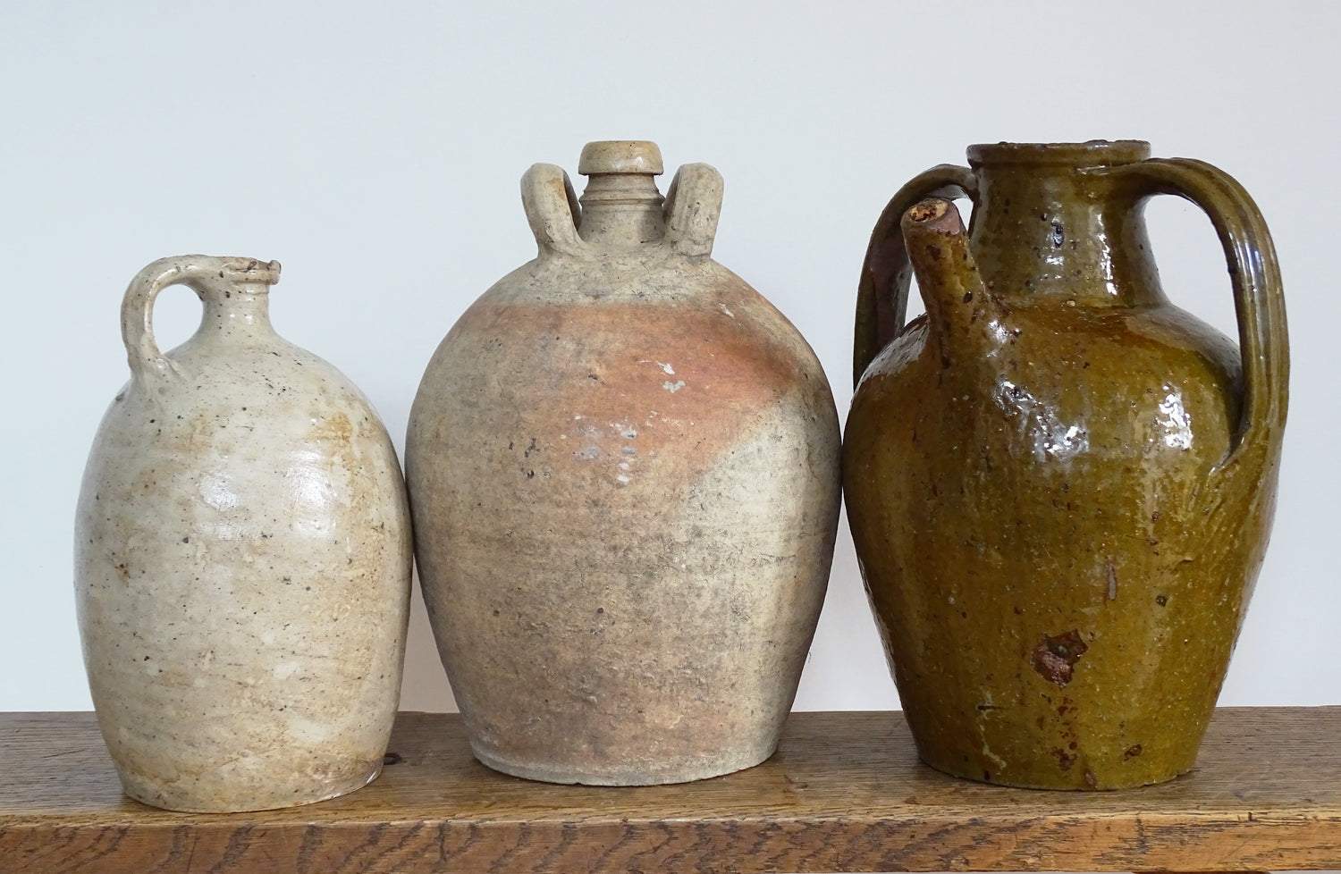 Antique French pottery pitchers, terracotta jugs and a green glazed terracotta walnut oil jug. 