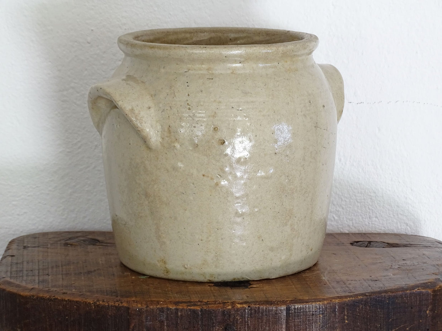 Antique French stoneware confit pot or preserving pot glazed in a pale oatmeal or sand colour. This crock pot or cache pot has two curved handles to each side. 